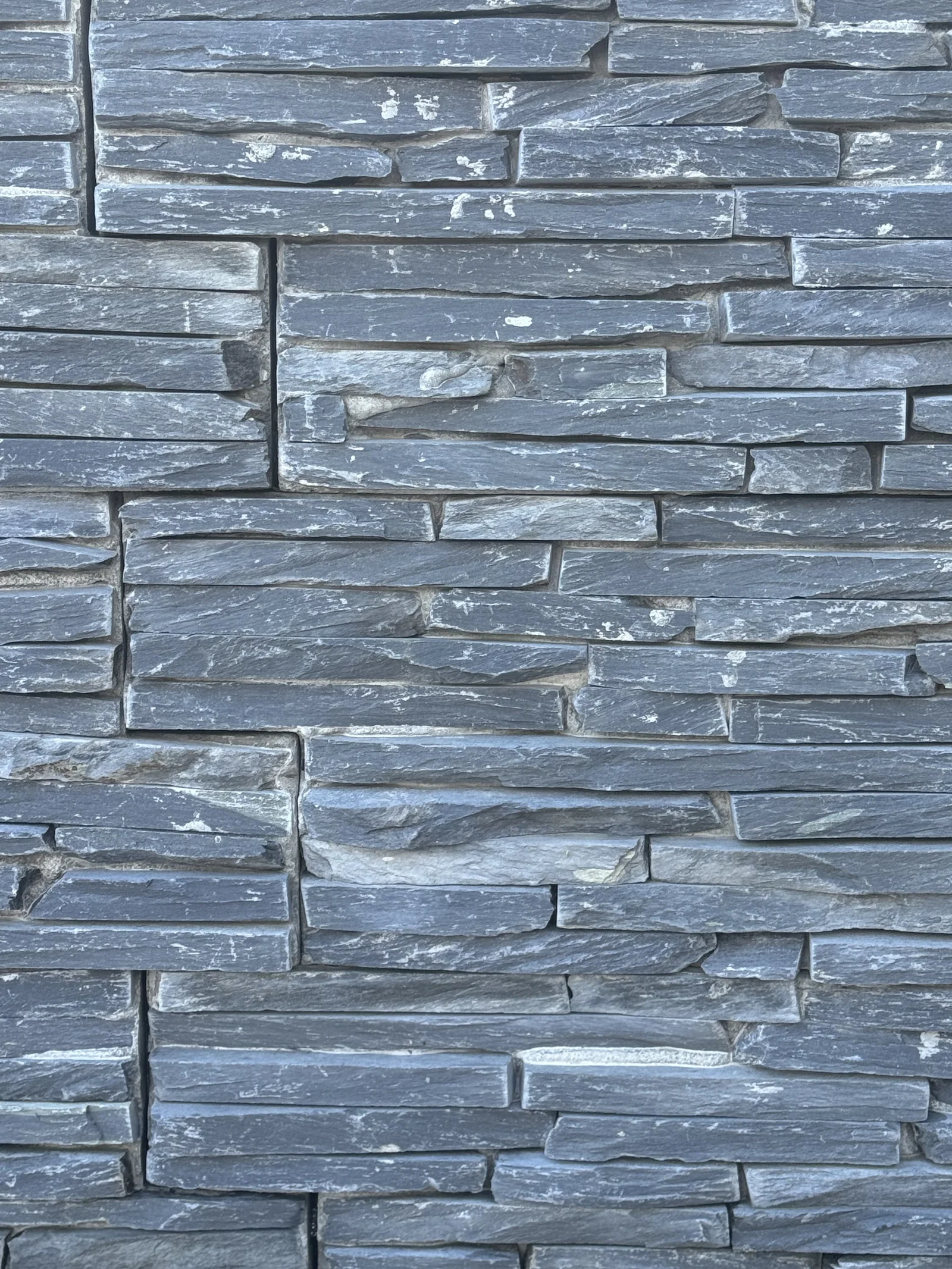 Black Slate stone cladding, thin dark slate strips in a ledgestone panel