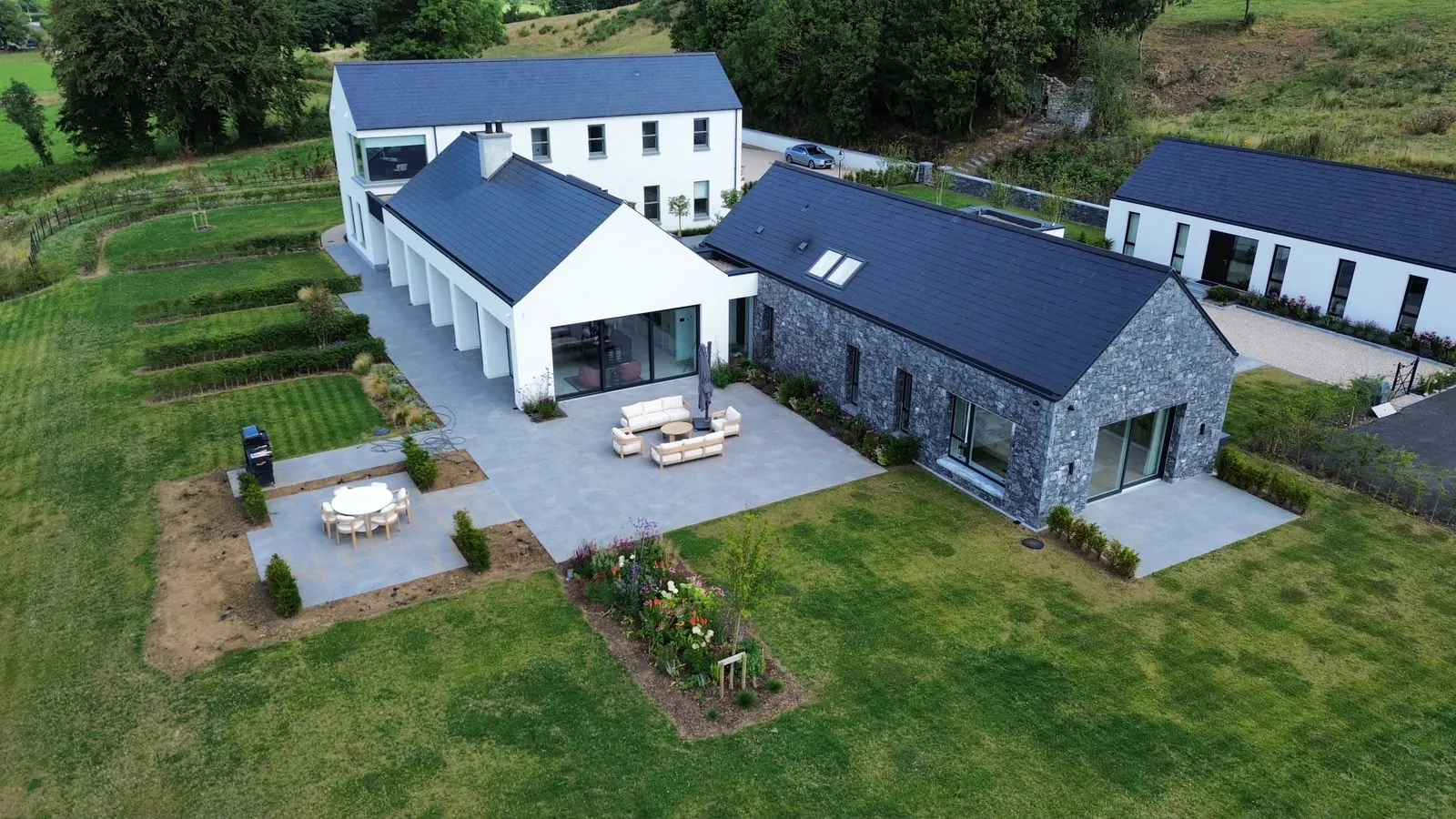 Aerial view of a house extension with a paved patio, gravel border and lawn