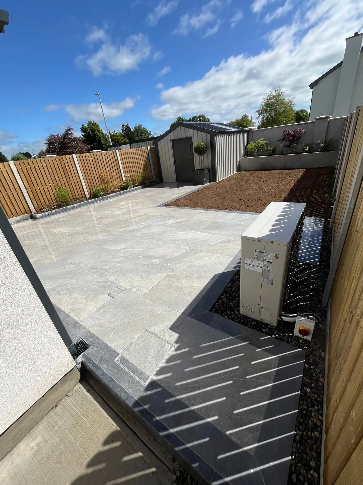 Pale stone patio with a composite privacy screen