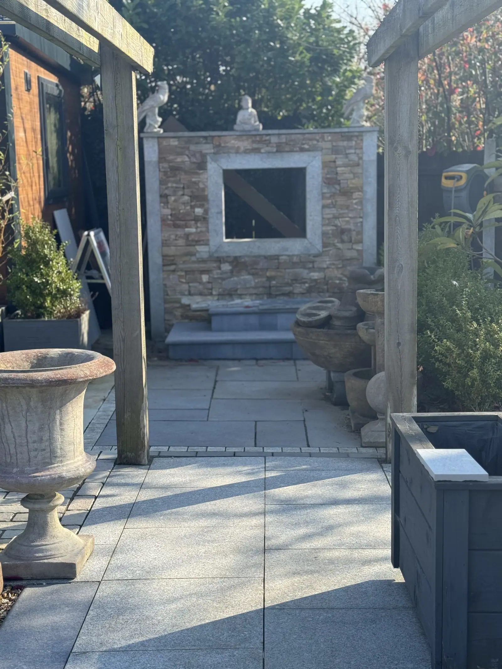 Cladded feature wall with a window opening beside a paved patio display
