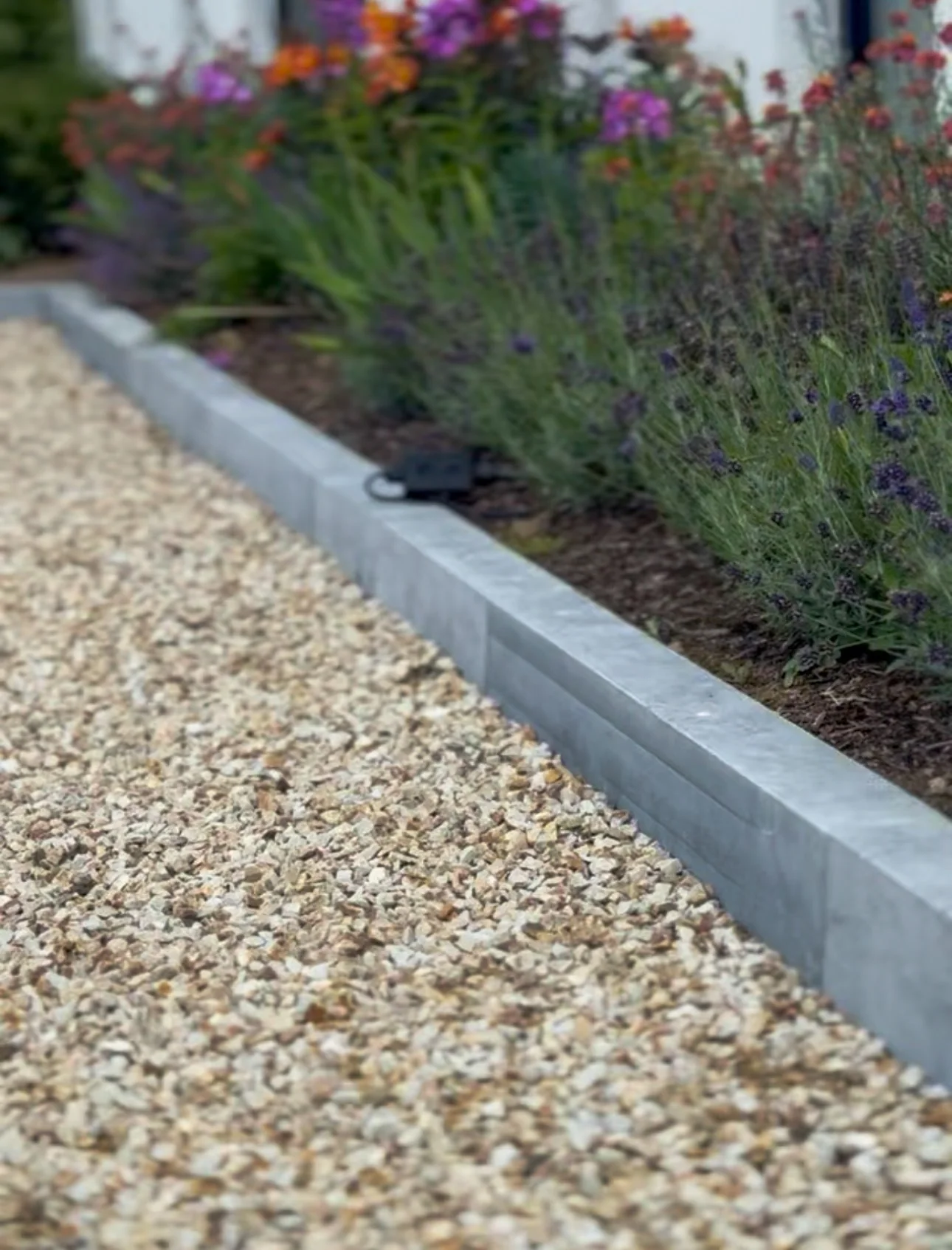 Irish Limestone kerbing edging a gravel path beside a planted flower bed