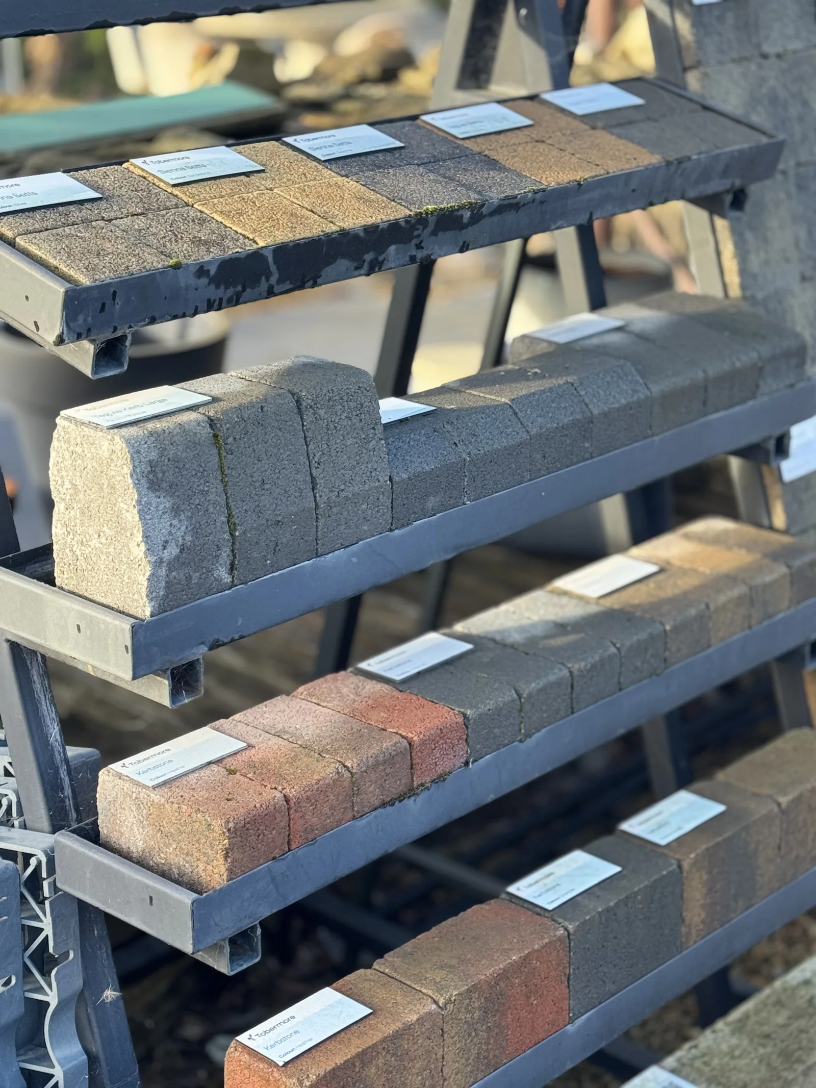 Kerbstone and paving samples on a display rack, labelled by type